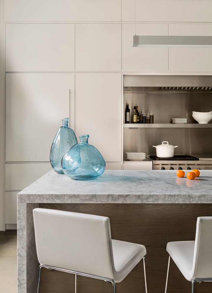 Exempel på ett modernt vit linjärt vitt kök med öppen planlösning, med släta luckor, bänkskiva i rostfritt stål, rostfria vitvaror, en köksö, grå skåp och stänkskydd i metallkakel
