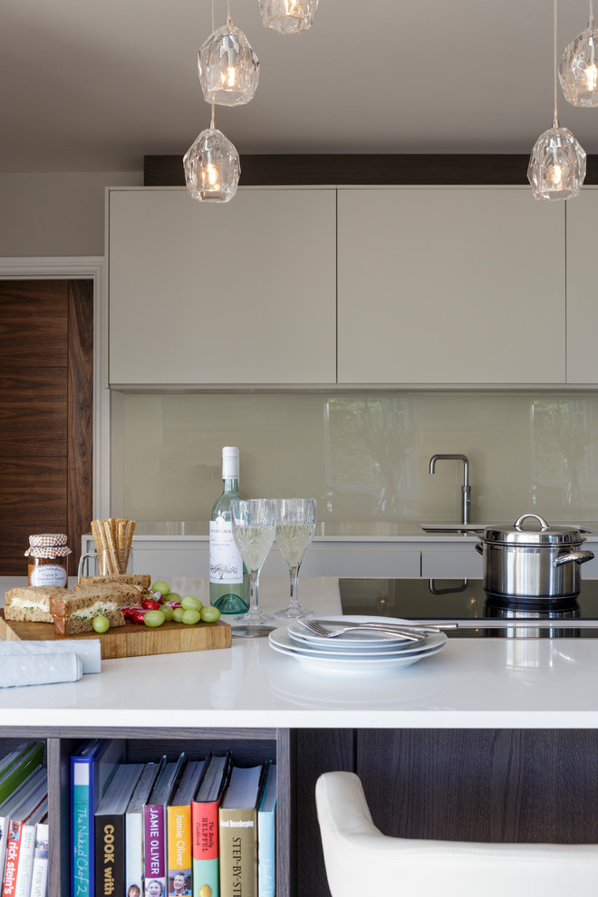Exempel på ett modernt kök och matrum, med en köksö, en undermonterad diskho, bänkskiva i kvartsit, svarta vitvaror och mellanmörkt trägolv