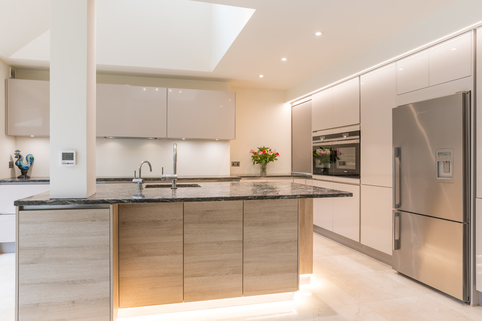 Large modern l-shaped kitchen in London with stainless steel appliances and an island.