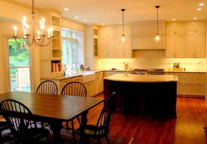 Inspiration for a mid-sized timeless l-shaped medium tone wood floor eat-in kitchen remodel in New York with a drop-in sink, recessed-panel cabinets, black cabinets, wood countertops, stainless steel appliances and an island