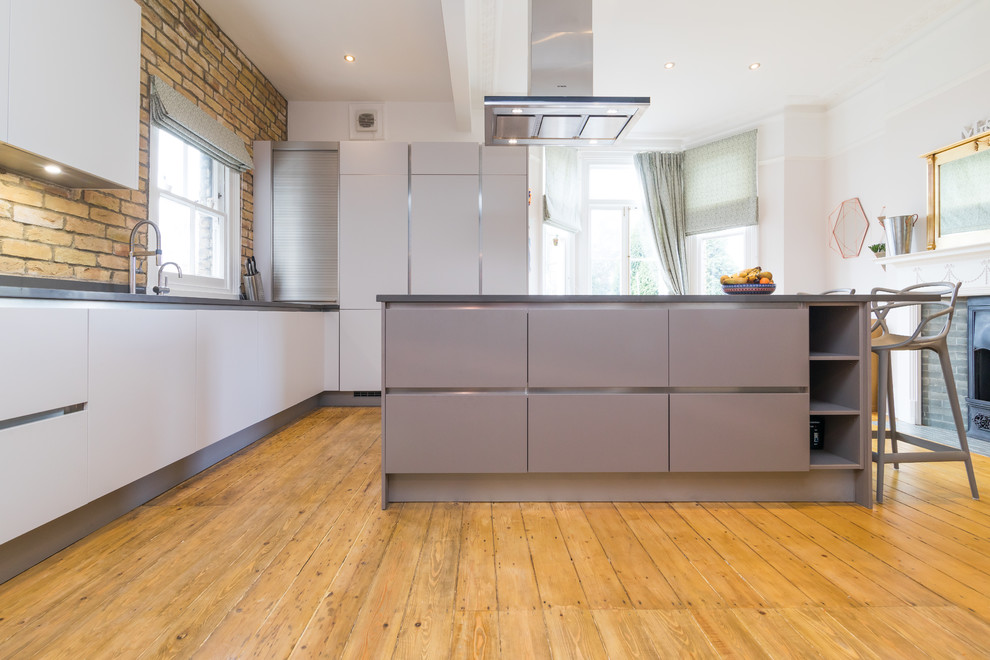Immagine di un cucina con isola centrale minimalista con ante lisce e ante grigie