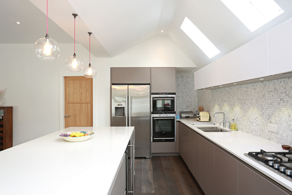 Idée de décoration pour une cuisine minimaliste de taille moyenne avec des portes de placard grises et îlot.