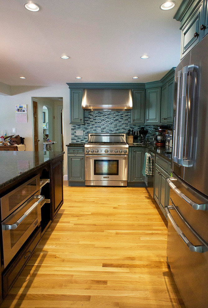 Große Klassische Wohnküche in L-Form mit Unterbauwaschbecken, türkisfarbenen Schränken, Granit-Arbeitsplatte, bunter Rückwand, Küchengeräten aus Edelstahl, braunem Holzboden und Kücheninsel in Boston