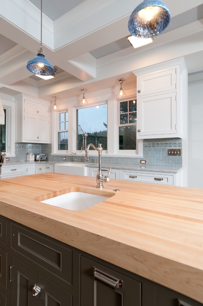 Klassische Küche mit Unterbauwaschbecken, Arbeitsplatte aus Holz, Schrankfronten mit vertiefter Füllung, weißen Schränken und Küchenrückwand in Blau in Portland