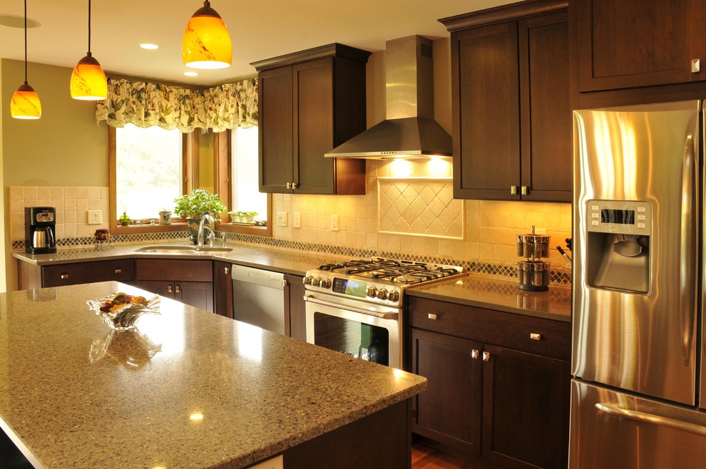 Example of a classic single-wall medium tone wood floor eat-in kitchen design in Other with a double-bowl sink, dark wood cabinets, beige backsplash, ceramic backsplash, stainless steel appliances, an island, quartzite countertops and flat-panel cabinets
