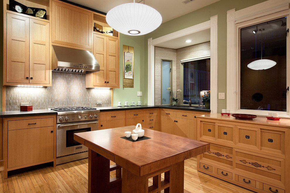 Imagen de cocina de estilo zen con electrodomésticos de acero inoxidable, encimera de madera y puertas de armario de madera oscura