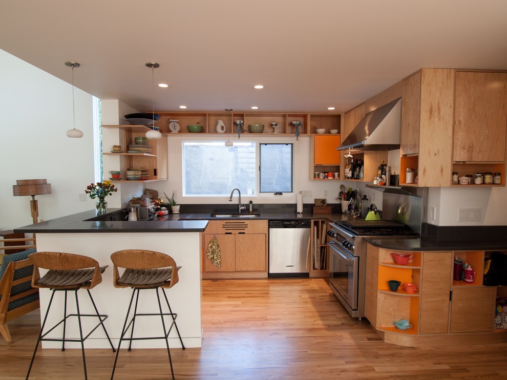 Foto på ett funkis kök, med rostfria vitvaror, öppna hyllor och skåp i ljust trä