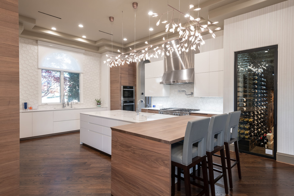 Example of a large trendy u-shaped medium tone wood floor and brown floor enclosed kitchen design in Dallas with a single-bowl sink, flat-panel cabinets, light wood cabinets, quartz countertops, white backsplash, cement tile backsplash, paneled appliances, an island and white countertops