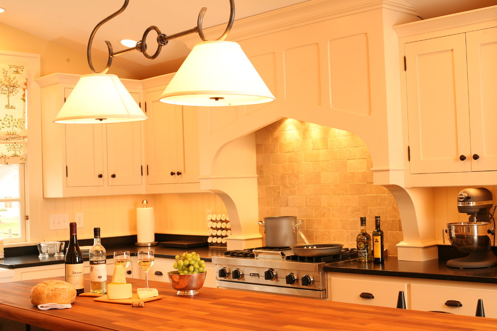 Foto de cocina tradicional con armarios estilo shaker, puertas de armario beige, encimera de madera, salpicadero beige y electrodomésticos de acero inoxidable