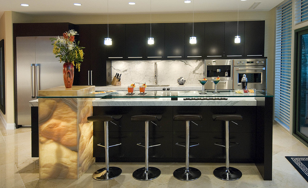 Example of a trendy galley kitchen design in Louisville with stainless steel appliances, marble countertops, flat-panel cabinets, black cabinets, white backsplash and marble backsplash