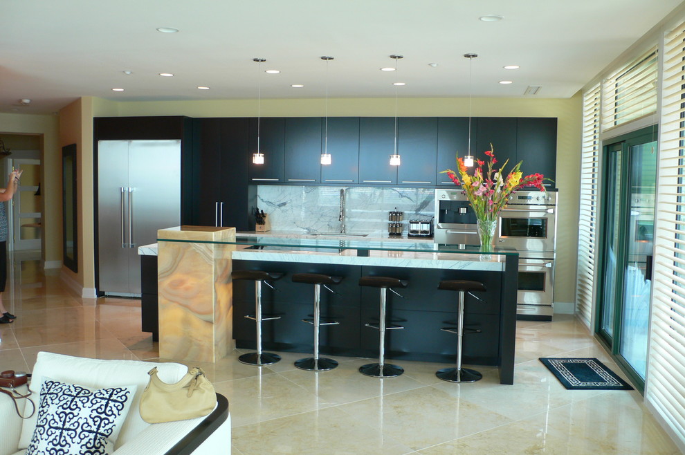 This is an example of a contemporary open plan kitchen in Louisville with stainless steel appliances, marble worktops, flat-panel cabinets, black cabinets, white splashback and stone slab splashback.