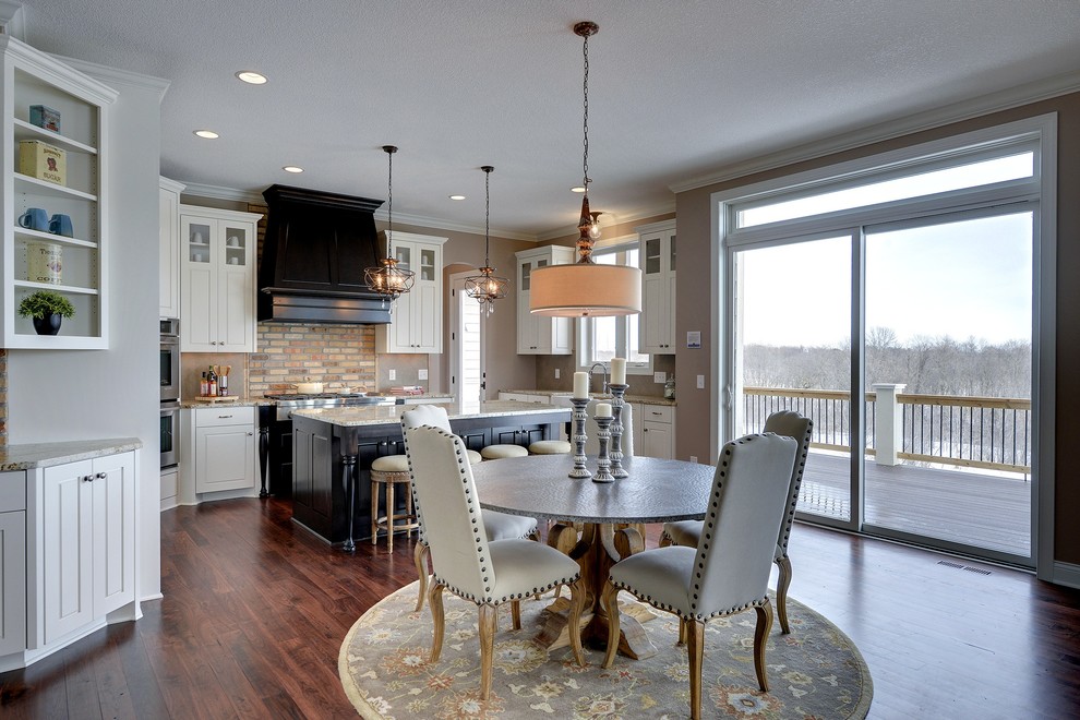 Example of a large transitional medium tone wood floor eat-in kitchen design in Minneapolis with white cabinets, marble countertops, beige backsplash and an island