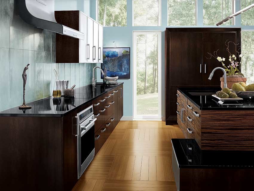 Design ideas for a medium sized world-inspired l-shaped kitchen/diner in Jackson with a submerged sink, flat-panel cabinets, dark wood cabinets, composite countertops, grey splashback, stone tiled splashback, integrated appliances, medium hardwood flooring and an island.