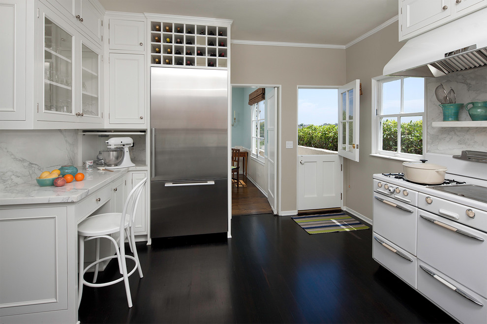 Elegant kitchen photo in Los Angeles with glass-front cabinets and stainless steel appliances