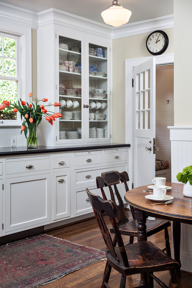 Foto de cocina tradicional cerrada con puertas de armario blancas, suelo de madera oscura, armarios estilo shaker, salpicadero blanco y salpicadero de azulejos tipo metro
