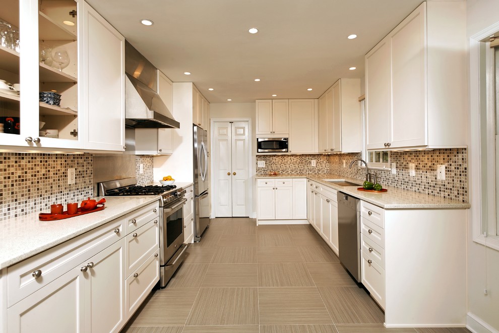 На фото: параллельная, отдельная кухня в классическом стиле с фартуком из плитки мозаики, техникой из нержавеющей стали, коричневым фартуком, врезной мойкой, фасадами с утопленной филенкой и белыми фасадами с