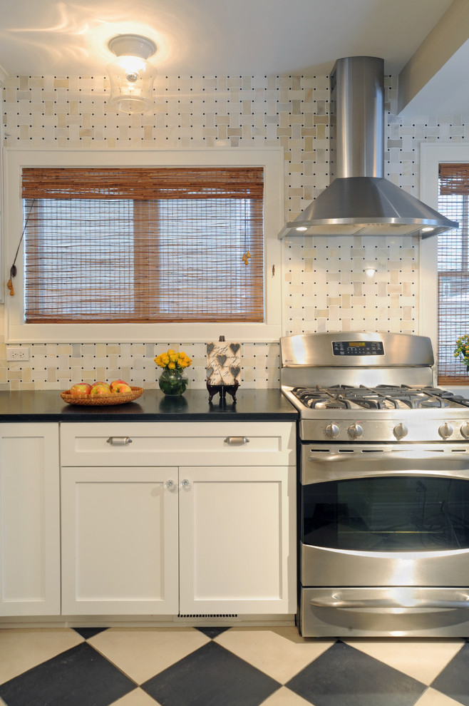 Cette image montre une cuisine traditionnelle avec un électroménager en acier inoxydable, un placard à porte shaker et des portes de placard blanches.