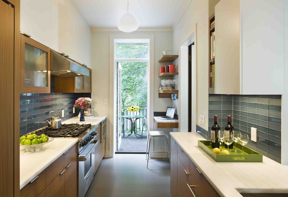 Réalisation d'une cuisine parallèle et bicolore minimaliste en bois brun fermée avec une crédence en carreau de verre, plan de travail en marbre, une crédence bleue et un placard à porte plane.