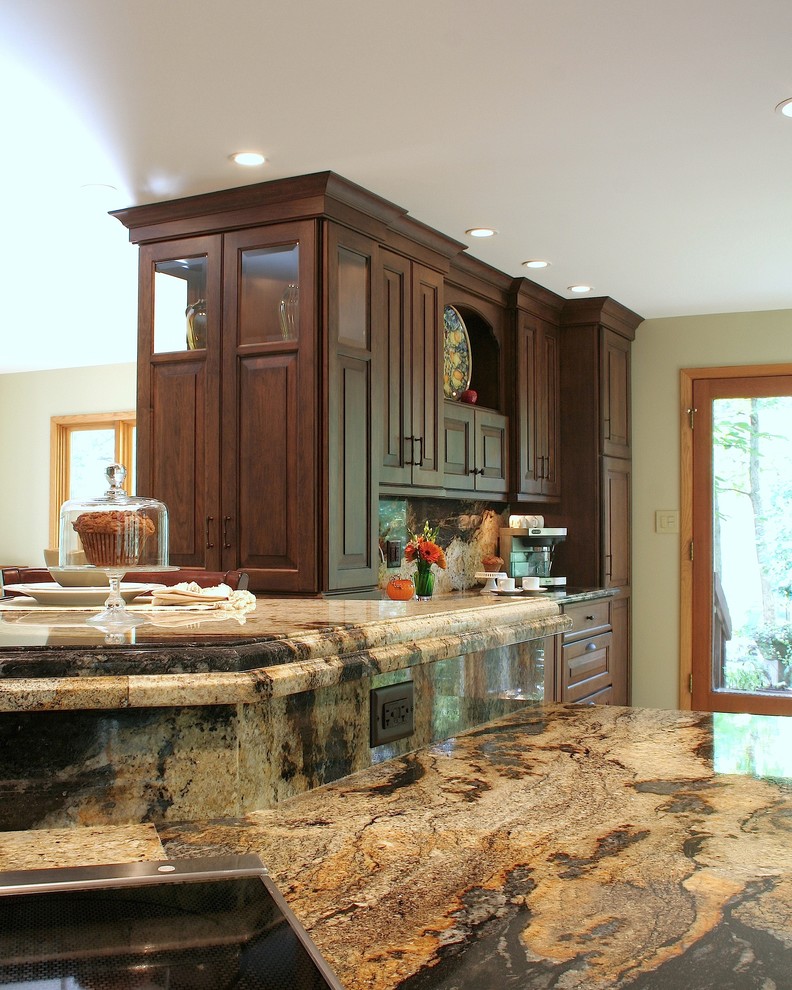 Immagine di un'ampia cucina abitabile classica con top in granito, parquet chiaro, ante con bugna sagomata, ante in legno bruno, paraspruzzi beige e penisola