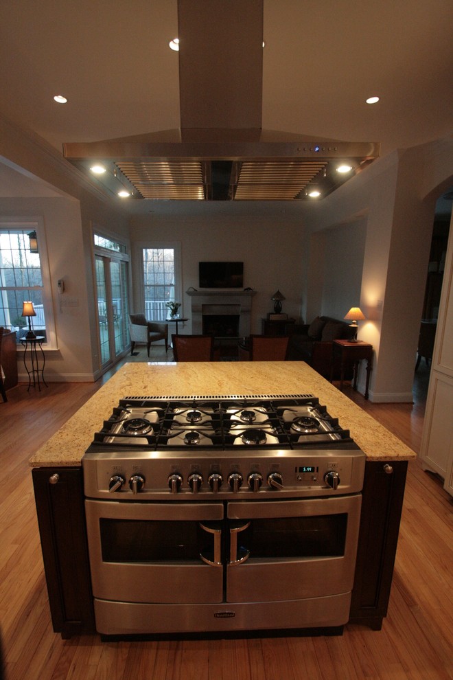Foto di una cucina ad U tradizionale con lavello stile country, ante a filo, ante beige, top in granito, paraspruzzi beige e elettrodomestici da incasso