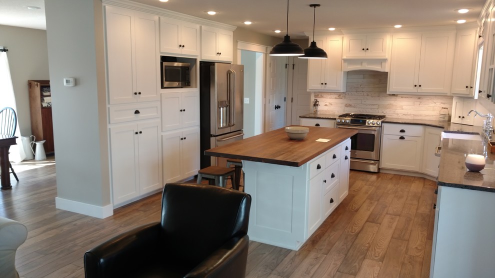 Eat-in kitchen - mid-sized cottage u-shaped eat-in kitchen idea in Wichita with a farmhouse sink, shaker cabinets, quartz countertops, ceramic backsplash and an island