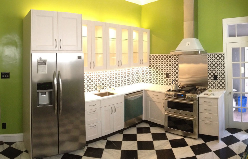 Inspiration for a small contemporary l-shaped ceramic tile enclosed kitchen remodel in Philadelphia with an undermount sink, glass-front cabinets, white cabinets, quartz countertops, multicolored backsplash, mosaic tile backsplash, stainless steel appliances and no island