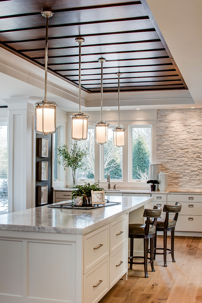 Inspiration for a large transitional l-shaped dark wood floor enclosed kitchen remodel in Indianapolis with shaker cabinets, white cabinets, marble countertops, white backsplash, glass sheet backsplash and an island