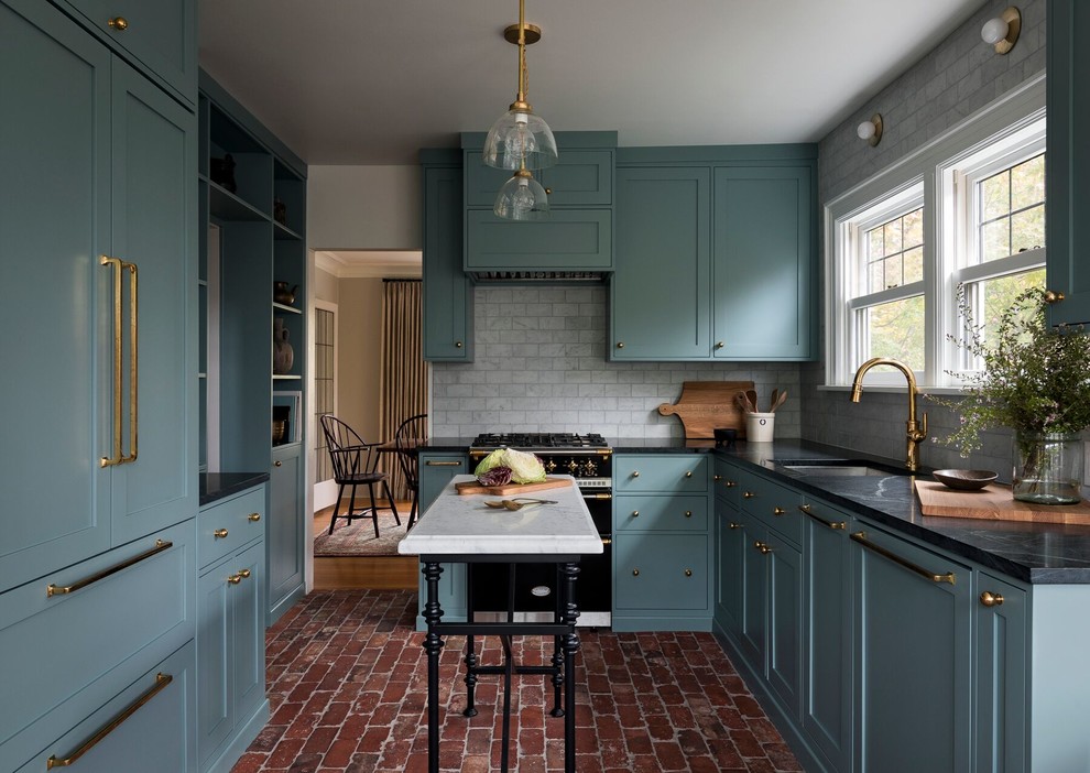 Idéer för ett avskilt, mellanstort klassiskt svart l-kök, med en undermonterad diskho, skåp i shakerstil, blå skåp, bänkskiva i täljsten, grått stänkskydd, stänkskydd i marmor, integrerade vitvaror, tegelgolv, en köksö och rött golv