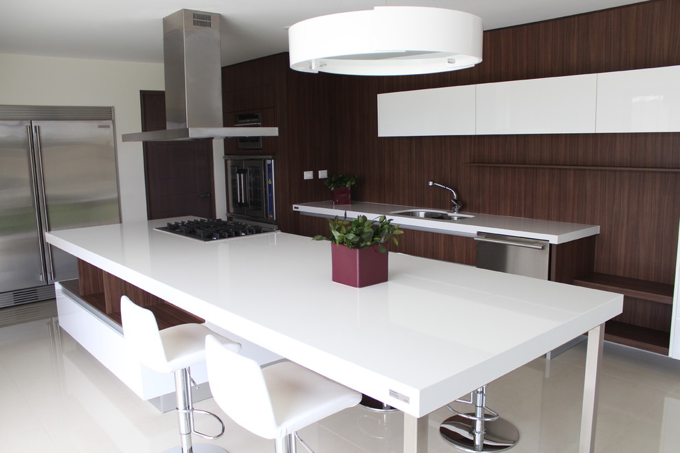 Стильный дизайн: прямая кухня в стиле фьюжн с обеденным столом, врезной мойкой, плоскими фасадами, коричневыми фасадами и столешницей из кварцита - последний тренд
