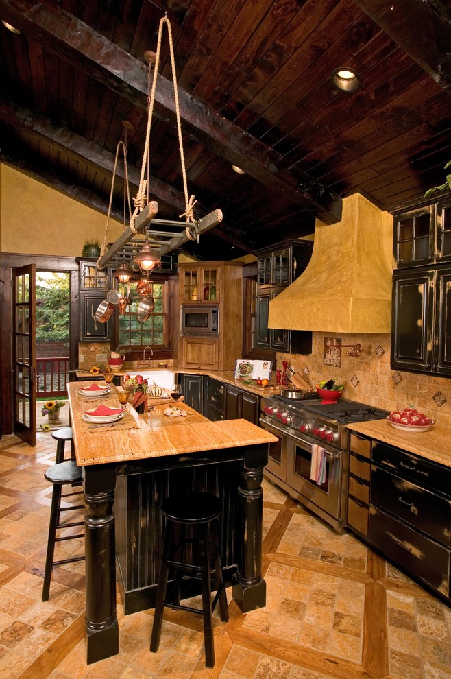 Photo of a medium sized rustic galley kitchen in Minneapolis with raised-panel cabinets, distressed cabinets, limestone worktops, beige splashback, stone tiled splashback, stainless steel appliances, travertine flooring, an island and beige floors.