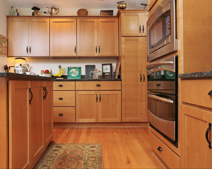 Immagine di una cucina stile americano di medie dimensioni con lavello a doppia vasca, ante lisce, ante in legno scuro, top in granito, paraspruzzi bianco, elettrodomestici in acciaio inossidabile e parquet chiaro