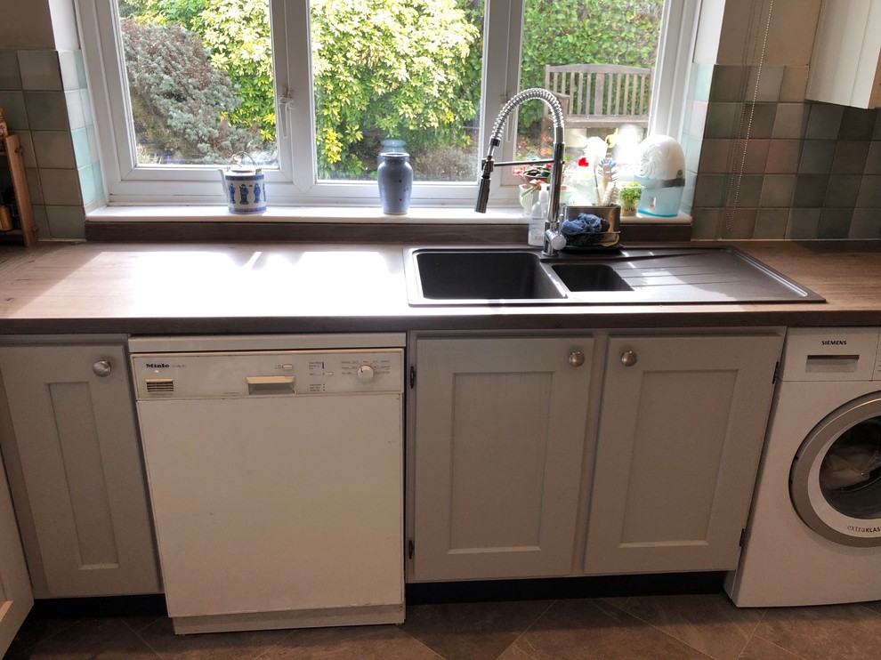 Rural kitchen in Oxfordshire with a built-in sink, shaker cabinets, grey cabinets, laminate countertops, vinyl flooring, grey floors and brown worktops.