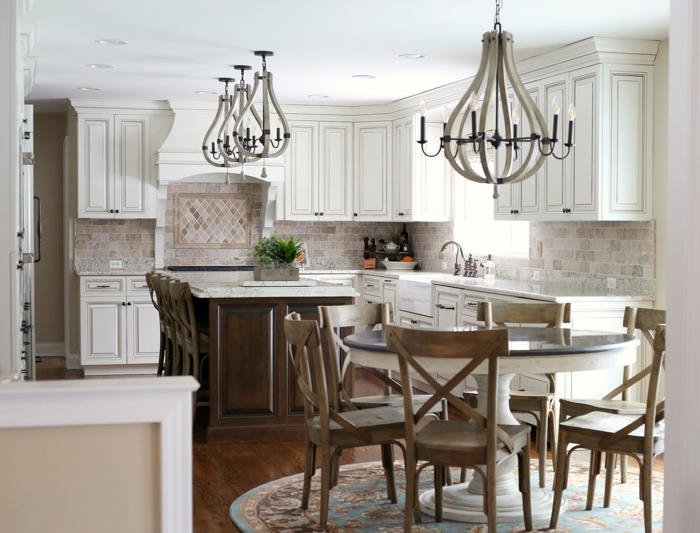 Eat-in kitchen - traditional medium tone wood floor eat-in kitchen idea in Chicago with a farmhouse sink, raised-panel cabinets, white cabinets, granite countertops, stone tile backsplash, paneled appliances and an island