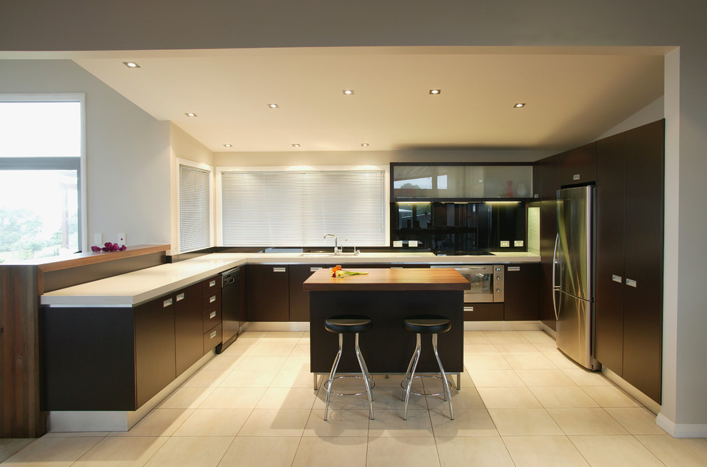 Diseño de cocinas en L contemporánea con electrodomésticos de acero inoxidable, armarios con paneles lisos y puertas de armario de madera en tonos medios