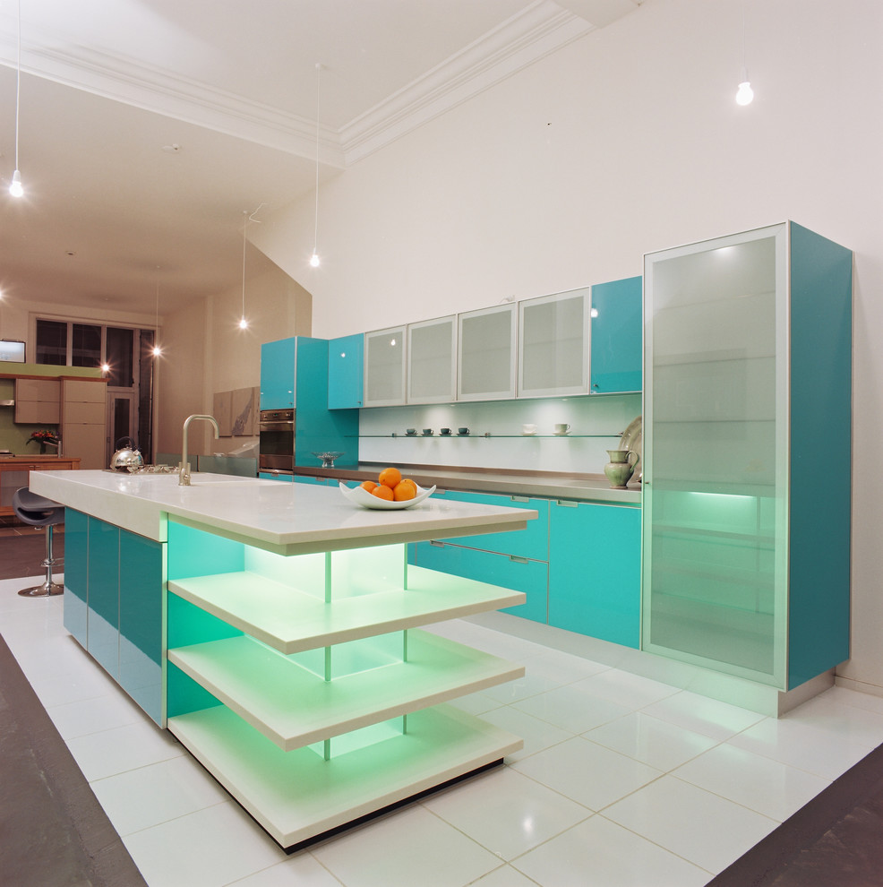 Exemple d'une cuisine parallèle tendance avec un placard à porte vitrée, des portes de placard turquoises et une crédence blanche.