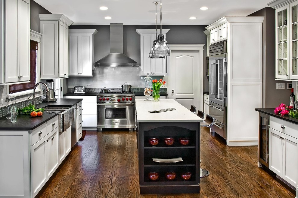 Contemporary grey and white kitchen in Chicago with shaker cabinets and stainless steel appliances.