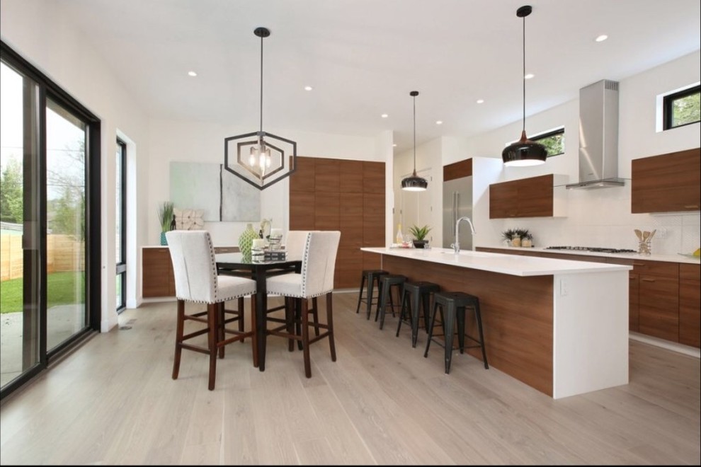 Inspiration for a modern l-shaped light wood floor and gray floor open concept kitchen remodel in Denver with a single-bowl sink, flat-panel cabinets, medium tone wood cabinets, quartz countertops, white backsplash, ceramic backsplash, stainless steel appliances and an island
