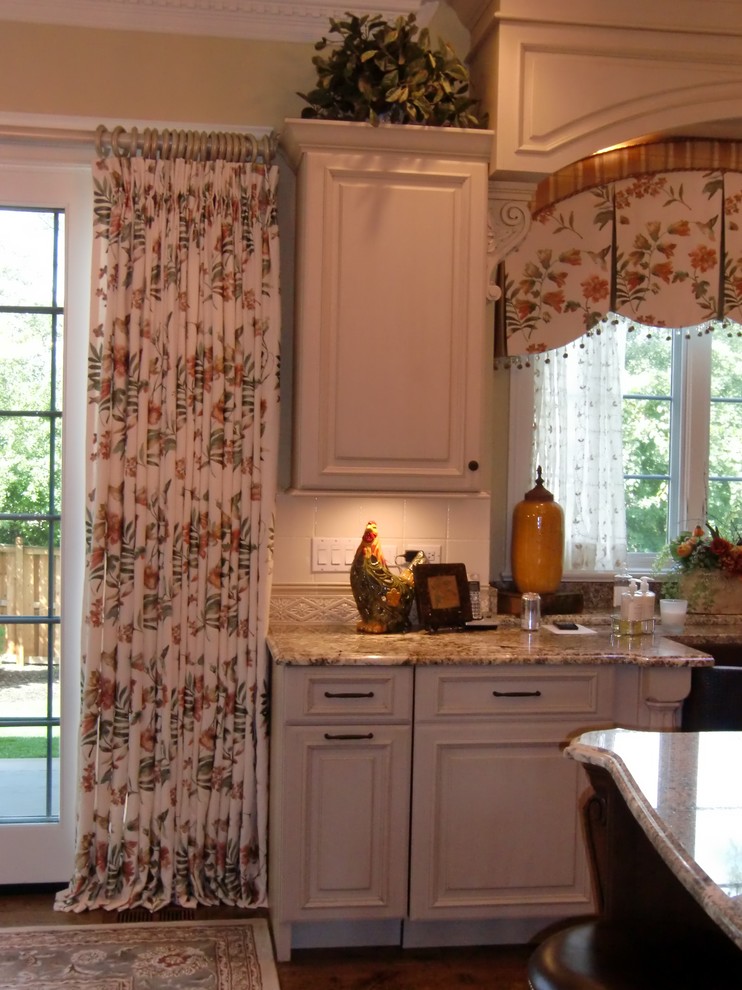 Mid-sized elegant eat-in kitchen photo in Chicago with recessed-panel cabinets and an island