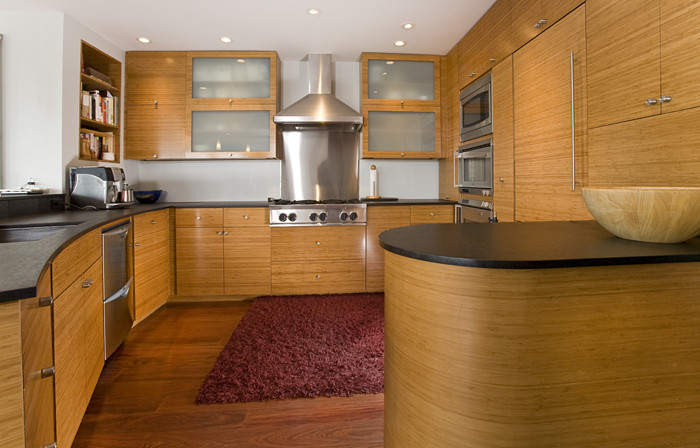 Idée de décoration pour une cuisine design en bois brun avec un électroménager en acier inoxydable.