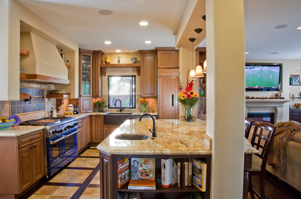 Example of a classic u-shaped open concept kitchen design in San Diego with a farmhouse sink, raised-panel cabinets, medium tone wood cabinets, granite countertops, multicolored backsplash and colored appliances