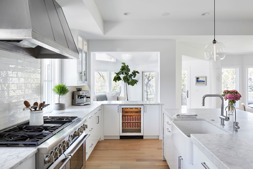 “best kitchen cabinet colors Canada: bright white shaker cabinets with marble countertops, stainless appliances, and light hardwood floors.”