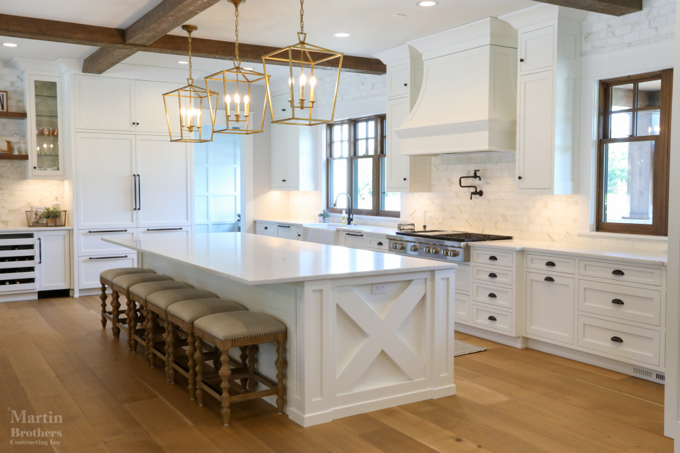 Exempel på ett stort lantligt vit vitt kök, med en rustik diskho, luckor med infälld panel, vita skåp, bänkskiva i kvarts, vitt stänkskydd, stänkskydd i marmor, integrerade vitvaror, ljust trägolv och en köksö
