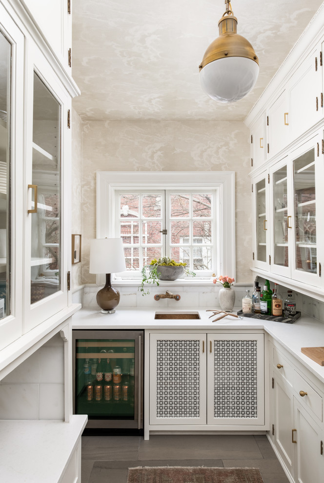 Idéer för avskilda vintage vitt u-kök, med en undermonterad diskho, luckor med infälld panel, vita skåp, vitt stänkskydd, rostfria vitvaror och brunt golv