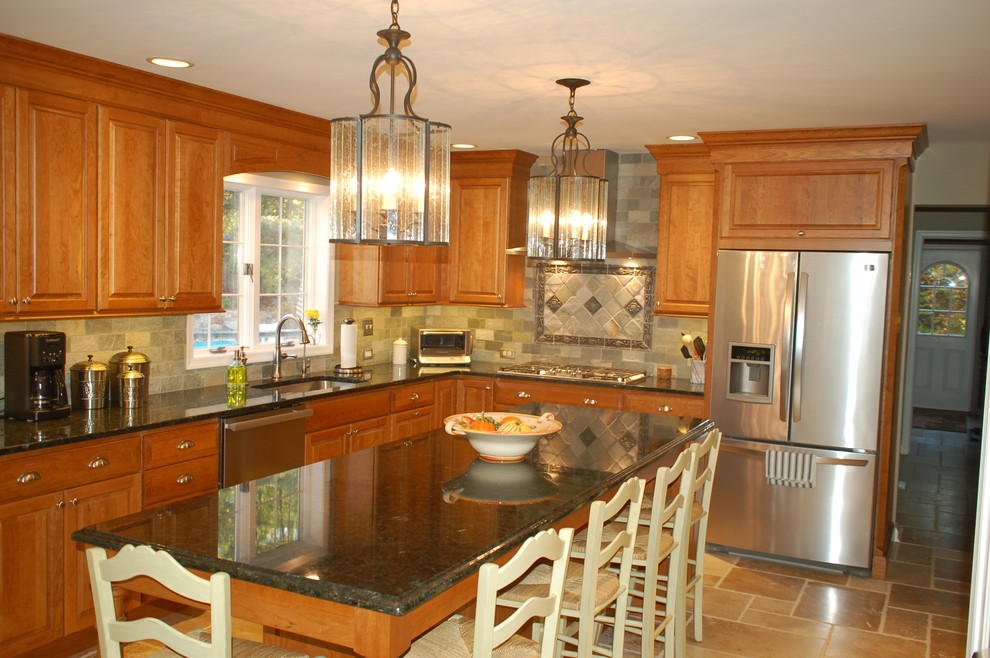 Bild på ett stort vintage kök, med en undermonterad diskho, luckor med upphöjd panel, skåp i mellenmörkt trä, granitbänkskiva, rostfria vitvaror, grått stänkskydd, stänkskydd i stenkakel, kalkstensgolv och en köksö