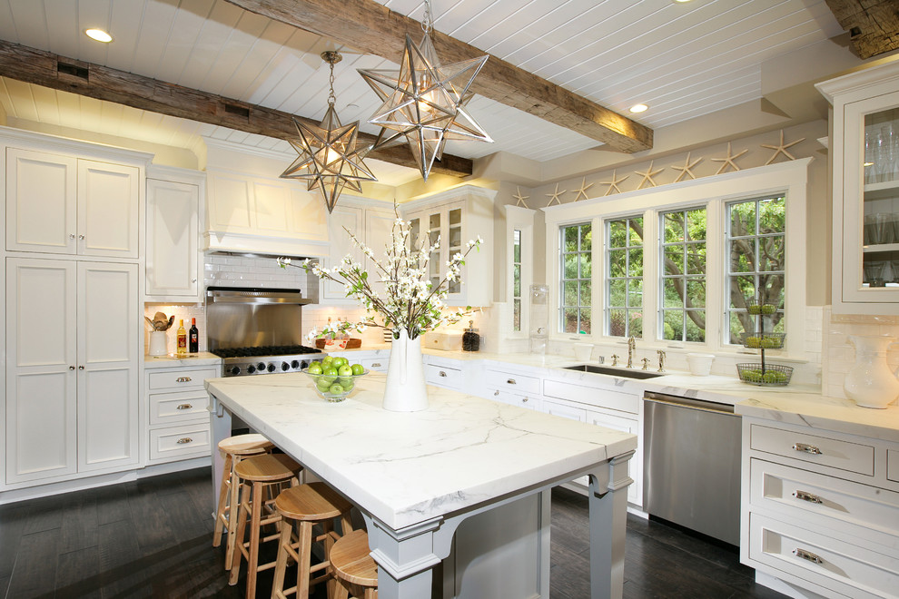 Idéer för ett klassiskt kök, med rostfria vitvaror, en undermonterad diskho, marmorbänkskiva, luckor med glaspanel, vita skåp och vitt stänkskydd