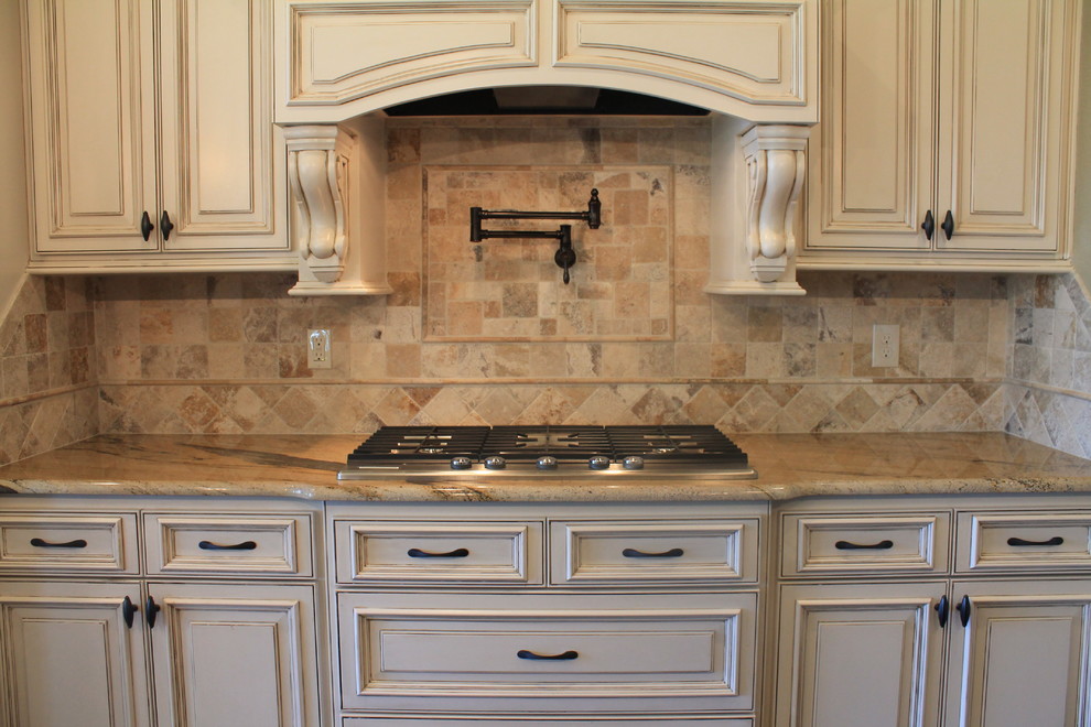 Inredning av ett klassiskt mellanstort kök, med vita skåp, granitbänkskiva, beige stänkskydd, stänkskydd i stenkakel och rostfria vitvaror