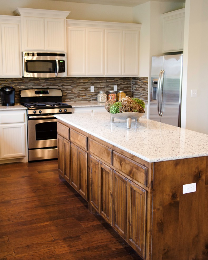 This is an example of a modern kitchen in Oklahoma City with beaded cabinets, white cabinets, multi-coloured splashback, glass tiled splashback, medium hardwood flooring and an island.