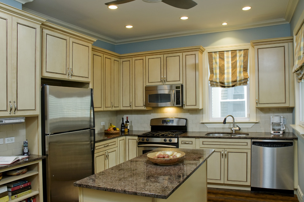 Klassische Küche in L-Form mit Küchengeräten aus Edelstahl, Unterbauwaschbecken, Küchenrückwand in Weiß und Rückwand aus Metrofliesen in Chicago