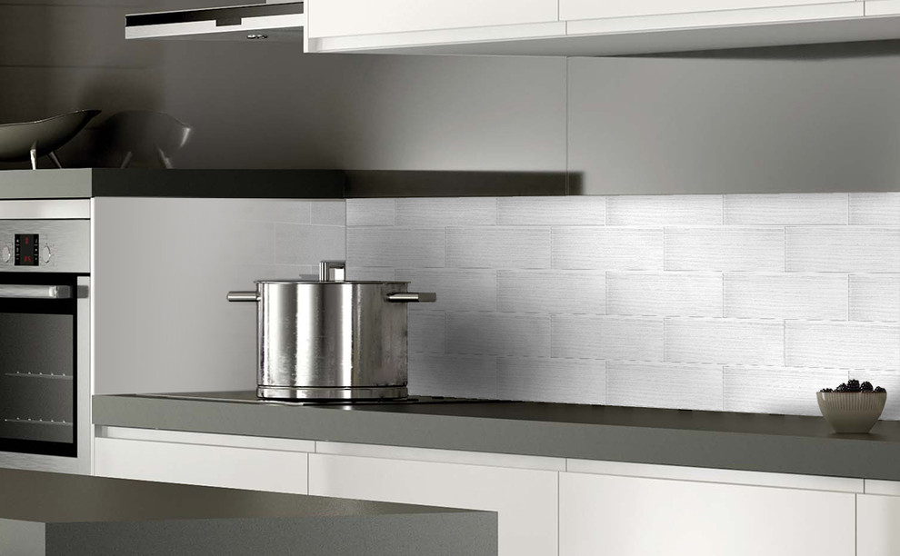 Bild på ett stort funkis linjärt kök och matrum, med släta luckor, vita skåp, laminatbänkskiva, vitt stänkskydd, stänkskydd i glaskakel, rostfria vitvaror och en köksö