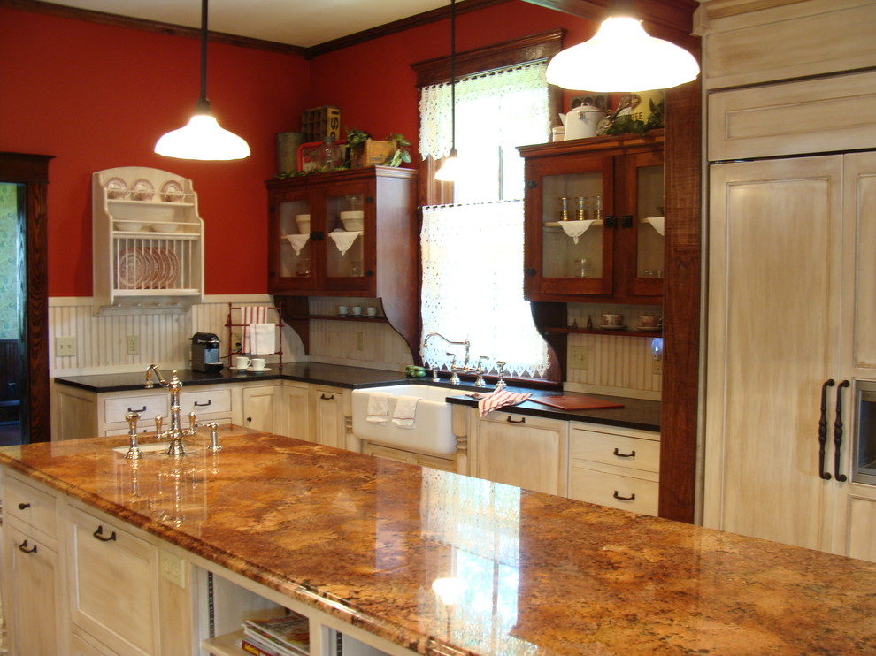Example of a large classic l-shaped enclosed kitchen design in Austin with a farmhouse sink, white cabinets, granite countertops, stainless steel appliances, shaker cabinets, beige backsplash and an island